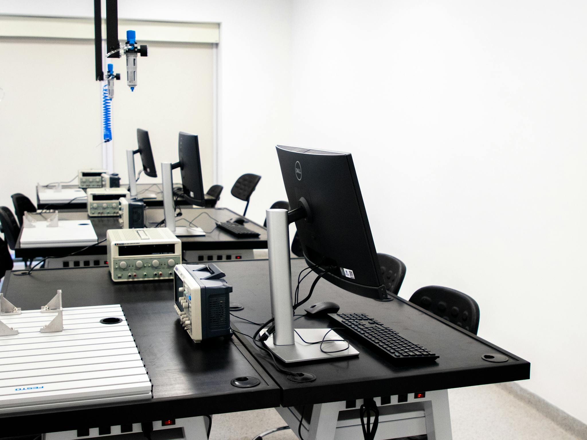 A contemporary electronics lab featuring computers, monitors, and various technical equipment on desks.