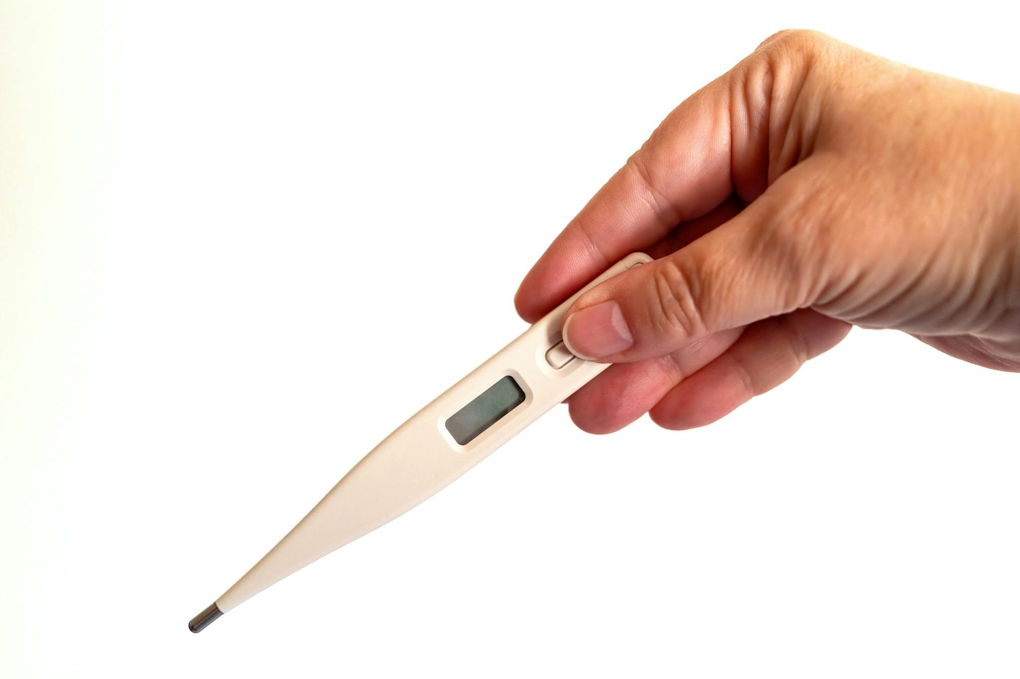 Close-up of a hand holding a digital thermometer, ideal for health and medical concepts.