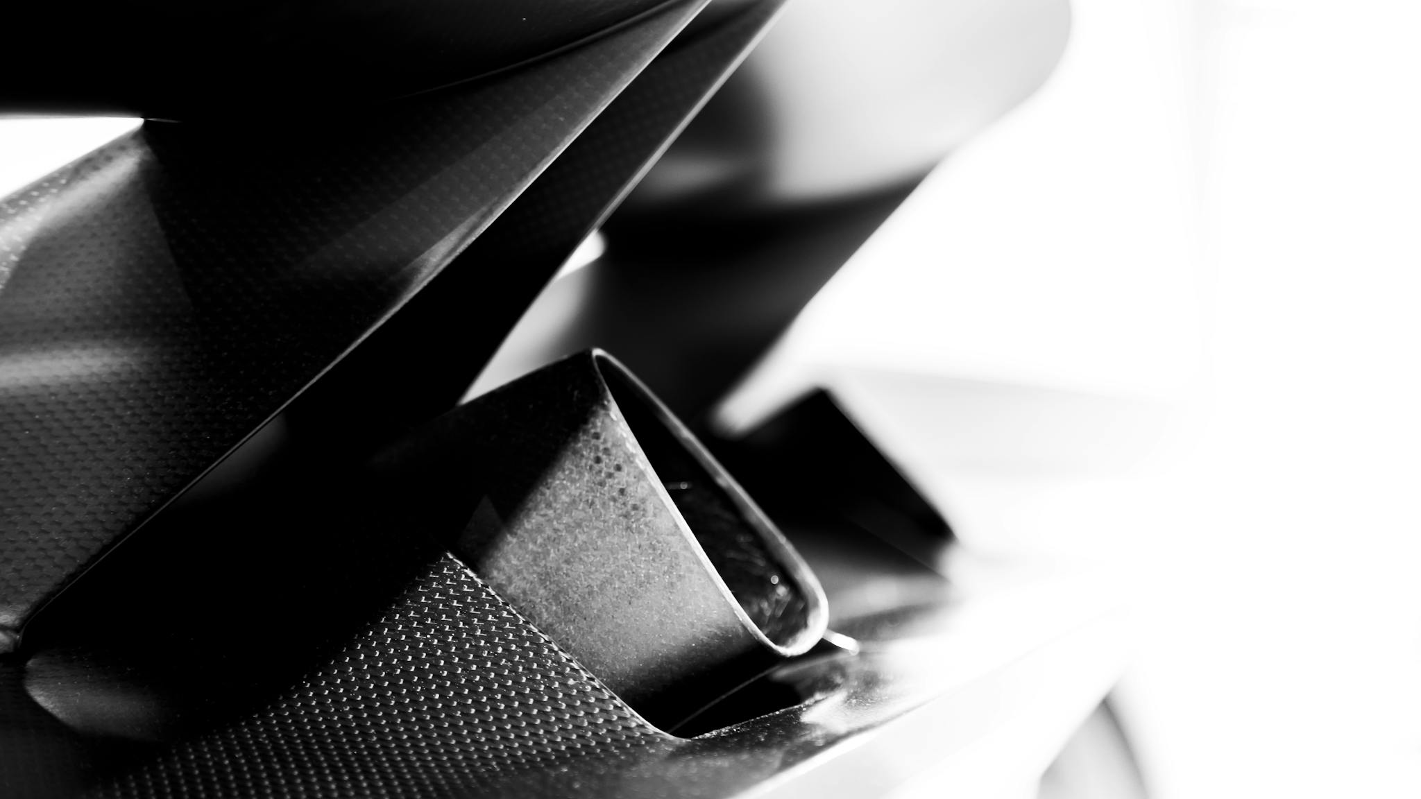 High contrast black and white detail of a carbon fiber component in modern design.